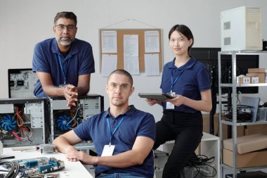 Bilgisayarlar ve çevreyle çevrili ofis ortamında iş birliği yapan bir grup bilişim uzmanı. Bireyler teknoloji ve fikirlerini paylaşıyorlar.