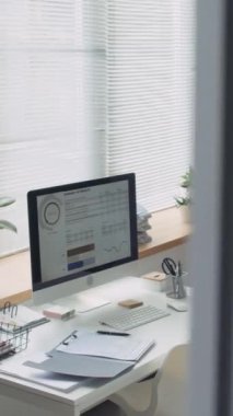 Kağıt, kırtasiye ve masaüstü bilgisayarının çizelgeleriyle ofis işyerinin dikey görüntüsü