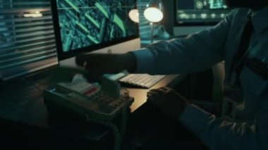 Kafkasyalı üniformalı askerin, bilgisayar başında otururken, şüpheli bir olay ya da uydu takibi tehdidi algılayıp, sabit telefondan üst düzey yetkililere...