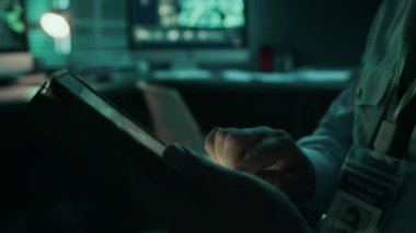 Kumanda merkezinde gece nöbeti sırasında tablet üzerinde dijital uydu keşif sistemi işleten, omuz bantlı, beyaz üniformalı olgun askerlerin yan çekimleri.