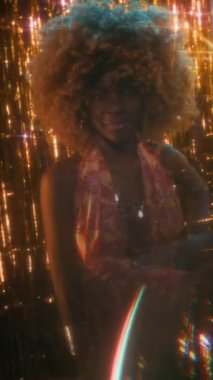 Kendine güvenen genç Afrikalı Amerikalı caz şarkıcısının dikey portresi. Renkli elbiseli kabarık saçlı. Parlak sahnede poz veriyor.