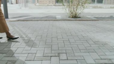 Tanınmayan iş ortaklarının, güneşli yaz gününde kaldırım taşları üzerinde yürümesi.