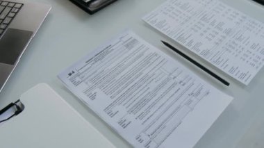 Ofisteki resmi vergi formlarının, kalemlerin, panoların ve dizüstü bilgisayarların görünümünü kapat