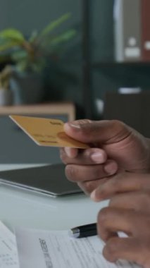 Kadın müşteriye kredi kartı veren tanınmayan bir banka memurunun dikey yakın çekimi.