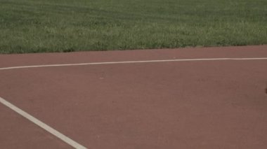 Uzuv farklılığı olan erkek atletin orta kalça kıvrımlı atışı. Pistte koşma, olta atma, yeşil çimlere cirit atma, açık havada yarışma antrenmanı yapma.