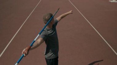 Aheiria engelli erkek atletin yüksek açılı arka şutu, tek eli olmadan, nişan alıyor, olta atıyor ve stadyumdaki tekniği geliştirirken yeşil çimlere cirit atıyor.