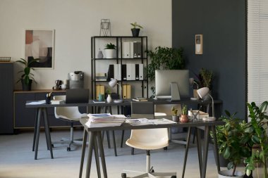 Finansal analistlerin işyerlerinde geniş ofislerdeki masalarda bilgisayarları, lambaları ve finansal kağıt yığınları var.