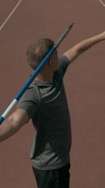 Aheiria engelli erkek sporcunun dikey yüksek açılı arka şutu. Stadyumda şampiyonluk antrenmanı yaparken nişan alıyor, nişan alıyor ve sonra yeşil alana cirit atıyor.