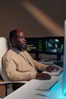 Masaüstü bilgisayar ekranına bakarken ve tuş takımındaki tuşlara basarken veri çözen olgun bilişim destek yöneticisi