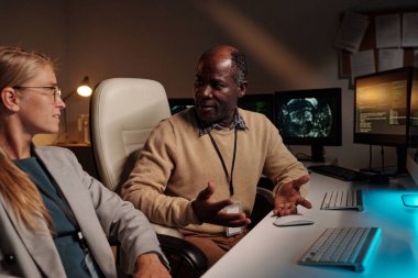 Kendine güvenen erkek programcı toplantıda sarışın meslektaşlarına veri çözmenin yollarını anlatıyor.