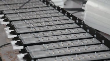 Işıklandırma sistemleri imalat şirketinin atölyesindeki montaj masasındaki endüstriyel LED lambaların yarı bitmiş bileşenlerine orta ölçekli hiç kimse yakın çekim yapmaz.