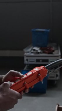 Dikey eğim yavaşlaması, siyah erkek depo çalışanının tulum, güvenlik yeleği, vinç kontrol panelindeki düğmelere basma ve nakledilen kargoyu izlemesi.