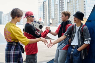 Kaykay parkında buluşan ve etkileşime geçen bir grup genç, güneşli bir günde arkadaşça sohbetler ve açık hava aktivitelerinin keyfini çıkarıyorlar.