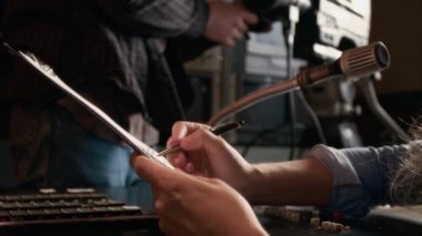 TV fragmanında mikrofonun önünde oturan, senaryoyla uğraşan, haber kaydı yapmadan önce notlar alan odaklanmış genç beyaz kadın gazetecinin ellerini ve yüzünü yana yatır.