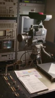 Video kamera veya kameranın orta boy görüntüsü yok, haber editörü çalışma istasyonunda mikrofon ses kontrollü, betik, yayın takvimi, TV prodüksiyon minibüsünde.