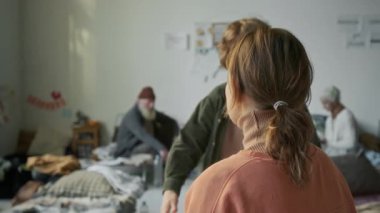 Sığınakta birlikte kalan bir grup mültecinin orta ölçekli bir fotoğrafı. Genç beyaz bir çocuk annesine doğru koşuyor ve yatakta oturup sarılıyor. Felaketten kurtulduktan sonra birbirlerini teselli ediyorlar.