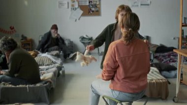 Kafkasyalı genç bir çocuğun, oyuncak ayıyı sıkıca tutarken, mülteci barınağında kamp sandalyesinde oturan annesine doğru koşarken, eve kaçtıktan sonra ona sevgiyle sarılırken,