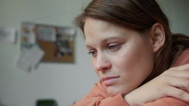 Depresyonda olan, ağlayan, beyaz bir kadının portresi. Acil konaklama yerinde oturan, dizlerinin üstünde oturan, felaketten sağ kurtulan arkadaşları ya da ailesi için endişelenen.