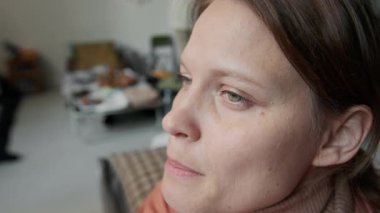 Sel, yangın, savaş, şiddet olaylarından kaçtıktan sonra mülteci kampında oturan beyaz kadın doğal afeti ya da savaştan sağ kurtulan kişinin yüzüne yakın duruş, arkadaşlarının ya da akrabalarının ölümü üzerine ağlama