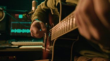 Modern neon ışıklı kayıt stüdyosunda şarkı ya da melodi çalan anonim müzisyenlerin yan görüntüsü, performans veya podcast için hazırlanıyor