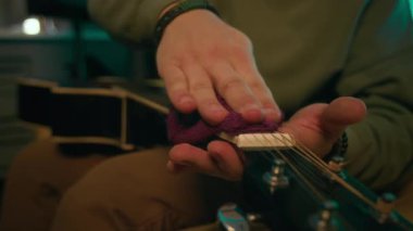 Tanınmayan müzisyenin elleri yakından çekilir. Klavyeyi dikkatlice temizler. Akustik gitarın başı da içeride yumuşak bir bez parçasıyla.