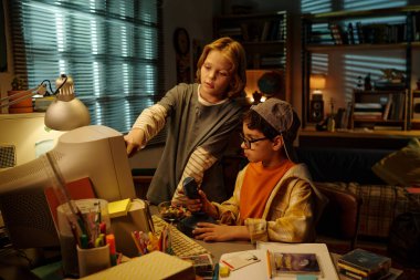 Kitap rafları, lambalar ve diğer klasik dekorlarla dolu rahat oturma odasında geçmişe dönük teknolojiyi keşfeden çocuklar eğitici bir ortam yaratıyorlar.