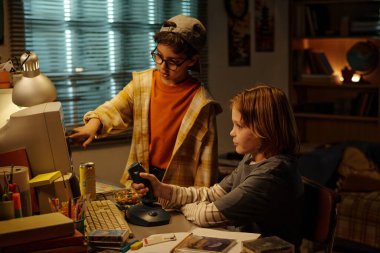 Çocuklar 90 'lı yılların çeşitli aletleri ve atıştırmalıklarıyla klasik bilgisayar üzerinde çalışıyor. Çevre aydınlatma ve retro dekor nostaljik atmosfer yaratıyor