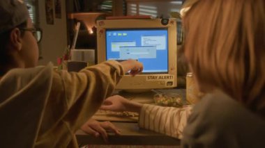 90 'ların sıcak tonlu evinde retro bilgisayarı birlikte kullanırken ekranı işaret eden iki çocuğun arka plan görüntüsü