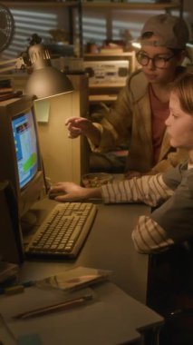 Bilgisayarı birlikte kullanan ve ekranı işaret eden iki 90 'ların çocuğunun dikey yan görüntüsü.