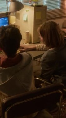 90 'larda retro video oyunları oynarken beşlik çakan iki çocuğun dikey yay görüntüsü