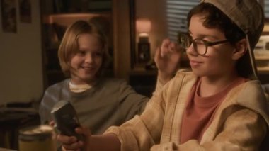 Yan görüntüde, genç bir çocuğun oyun oynarken omzuna vurduğu ve 90 'ların çocukluk ortamında tezahürat yaptığı bir video oyunu.