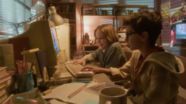 90 'ların nostaljik ortamında geçmişe dönük bilgisayar kullanarak oyun oynayan iki gülümseyen genç çocuk, arkadaşlarının kazanması ve tezahürat yapmaları