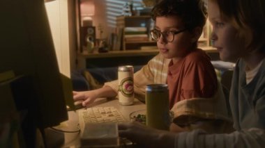 Eski okul bilgisayarını kullanan iki gencin yan görüntüsü. 90 'ların çocukluk konsepti.