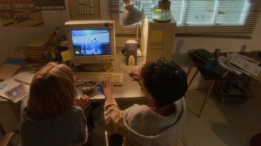 90 'ların çocukluk ortamında retro bilgisayar kullanarak video oyunu oynarken iki gencin çak bir beşlik yaptığı yüksek açılı çekim.