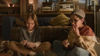 90 'lı yılların iki çocuğu yerde oturup sakız çiğnerken ve araba fotoğraflarıyla birlikte sakızlara bakarken.