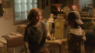 Evde dans eden iki 90 'ların çocuğunun arka planda retro bilgisayarla müzik dinlediği orta boy bir fotoğraf.