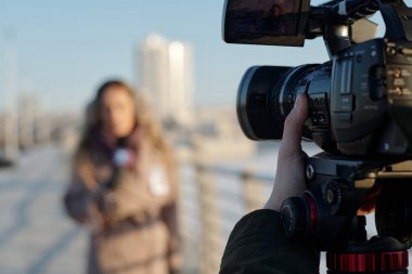 Video kameraya ve çekim sırasında tanınmayan genç operatör veya kameraman ayarlama ekipmanına odaklan