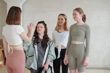 Spor giyim bölümündeki bayanı spor yapmadan önce yoga eğitmenine beşlik çakarken devre dışı bırak.