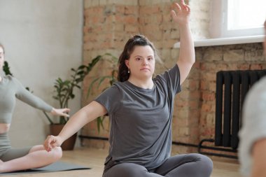 Spor giyim bölümündeki kadının antrenman sırasında yoga egzersizlerini tekrarlamasını engelle