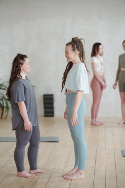 Yoga eğitiminden sonra bir müşteriyle konuşan genç ve mutlu bir antrenör.