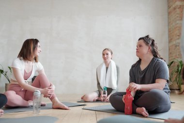 Beden eğitiminde yoga yaptıktan sonra dinlenen üç kız.