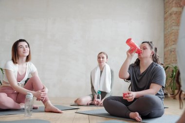 Molada yoga eğitiminden sonra su içen susuz bir kadın.
