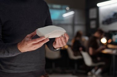 Yenilikçi Mühendislik Bürosu 'nun erkek tasarımcısının sunum sırasında beyaz araba modelini tutarken görüntüsü.