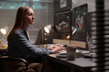 Genç yaratıcı kadın bilgisayar klavyesinin tuşlarına basıyor ve yeni bir otomobil modeli oluştururken ekrana bakıyor