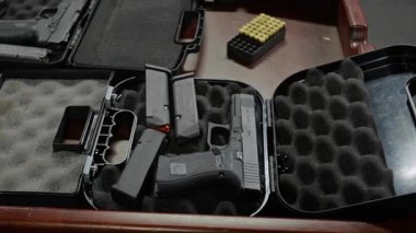 Köpüklü depolama çantasında, şarjörlü şarjörlü, mermili, atış poligonunda duran siyah yarı otomatik silah kullanan kimse yok.
