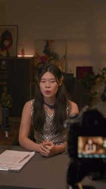 Canlı yayında güncel konularla ilgili görüşlerini belirten zarif genç Z Gen Çinli kadın podcast sunucusunun orta boy dikey görüntüsü.