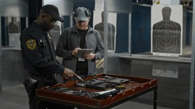 Orta yaşlı, siyah üniformalı siyahi polislerle dolu. Atış poligonunda durup tabancayı doldurma alıştırması yapıyorlar. Kafkas koçu ise tablet bilgisayarla izliyor.