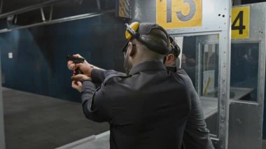 Kafkas erkek atış poligonu koçunun orta dereceli arka yayı. Siyahi polis öğrencileri için antrenman yapıyor. Düzgün tutuş ve nişan alma, hedefi gösterme, hataları izleme ve düzeltme.