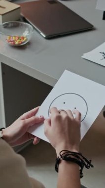Okul psikologuyla terapi seansında duygularını ve ruh halini değerlendirirken üzgün yüzlü depresif bir genç kızın omuz üstü fotoğrafı.