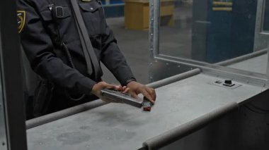 Atış poligonunda duran, şarjörü tabancaya dolduran, ateş etmeye hazırlanan genç Afrikalı Amerikalı polis memurunun medyumu, beyaz erkek koçun duruşunu düzeltirken,